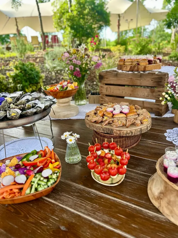 Buffet fleuri : huîtres, crudités, brochettes de tomates et fleurs sur une table en bois