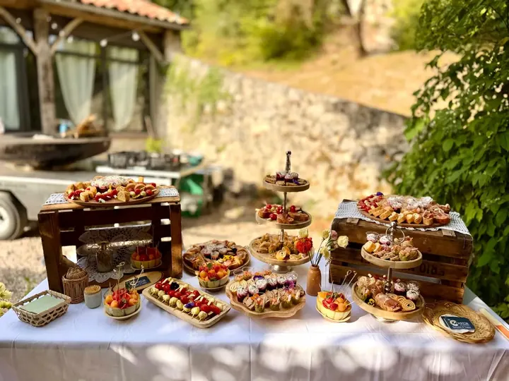 Buffet de présentoirs en bois garnis de bouchées salées et sucrées dans un jardin