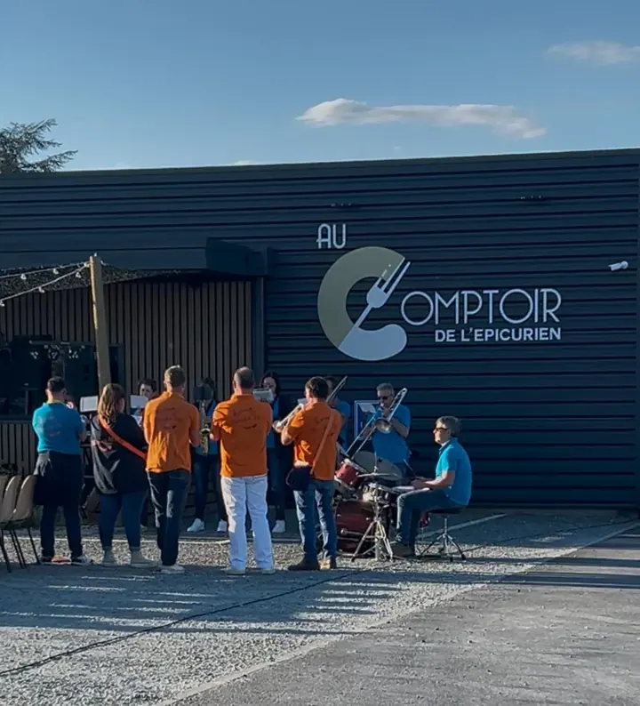 Façade du restaurant Au Comptoir de l'Épicurien avec des musiciens et leurs invités